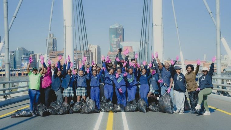 Group photo of volunteers from Jozi My Jozi and the Maharishi Invincibility Institute on the Nelson Mandela Bridge in Johannesburg on Mandela Day.